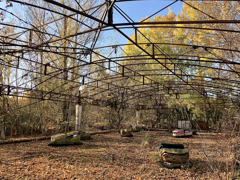 Besuch in Tschernobyl: Ihr Dach hat die Autoscooter-Halle im Laufe der vergangenen Jahrzehnte verloren. Einsam stehen die Wagen auf der ehemaligen Bahn.